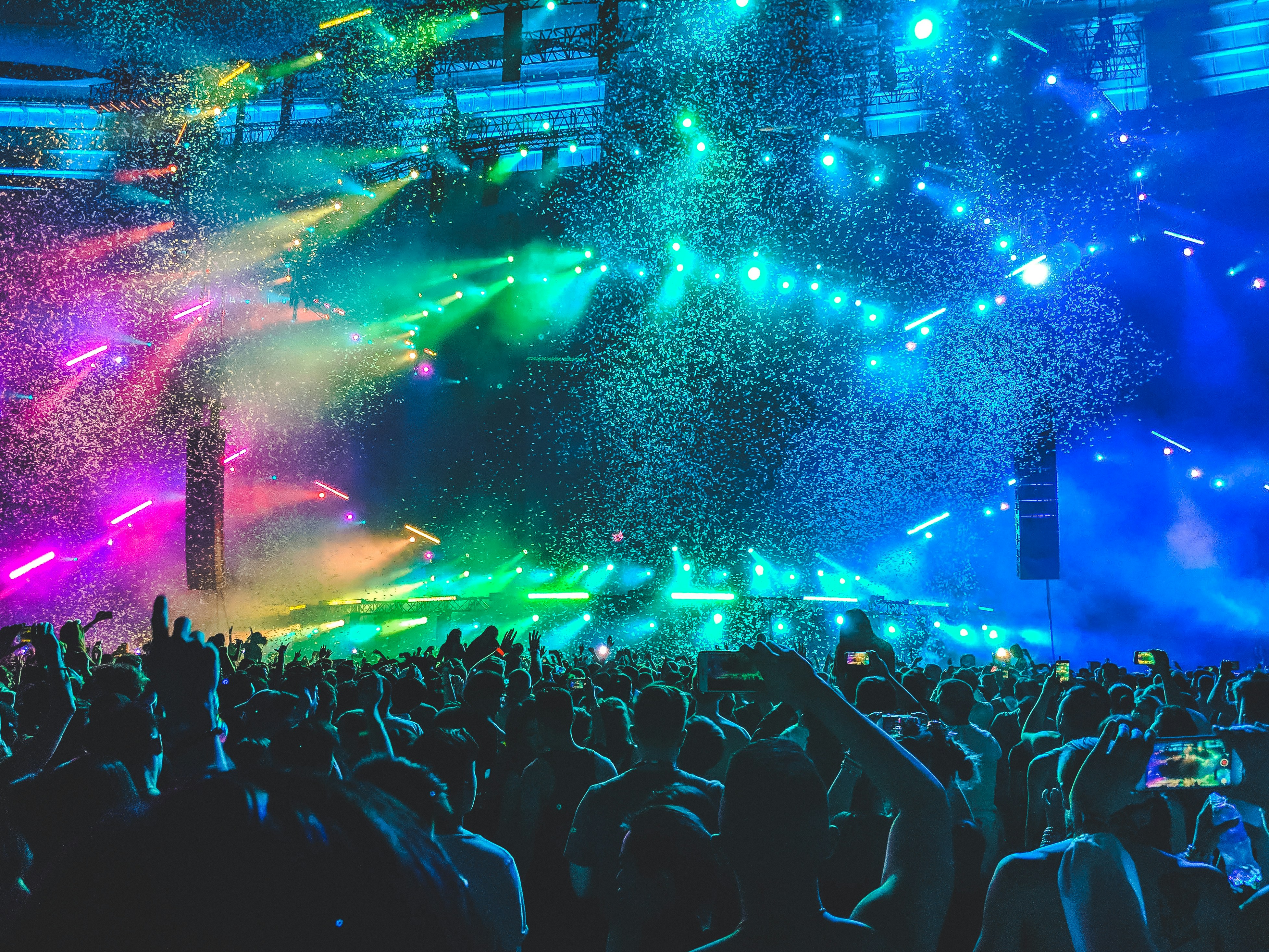 Stage lights, confetti raining over a crowd with phones held up to capture the moment.